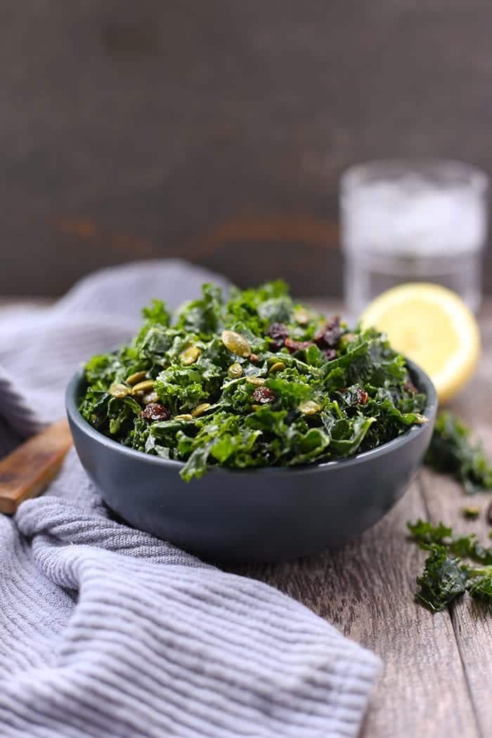 Kale salad with peptias and cranberries in a blue bowl