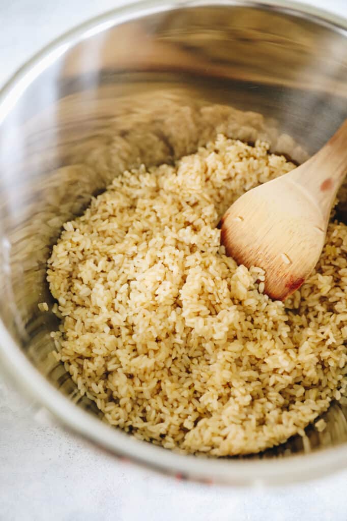 Brown rice in a large pot. Stir the rice with a wooden spoon.