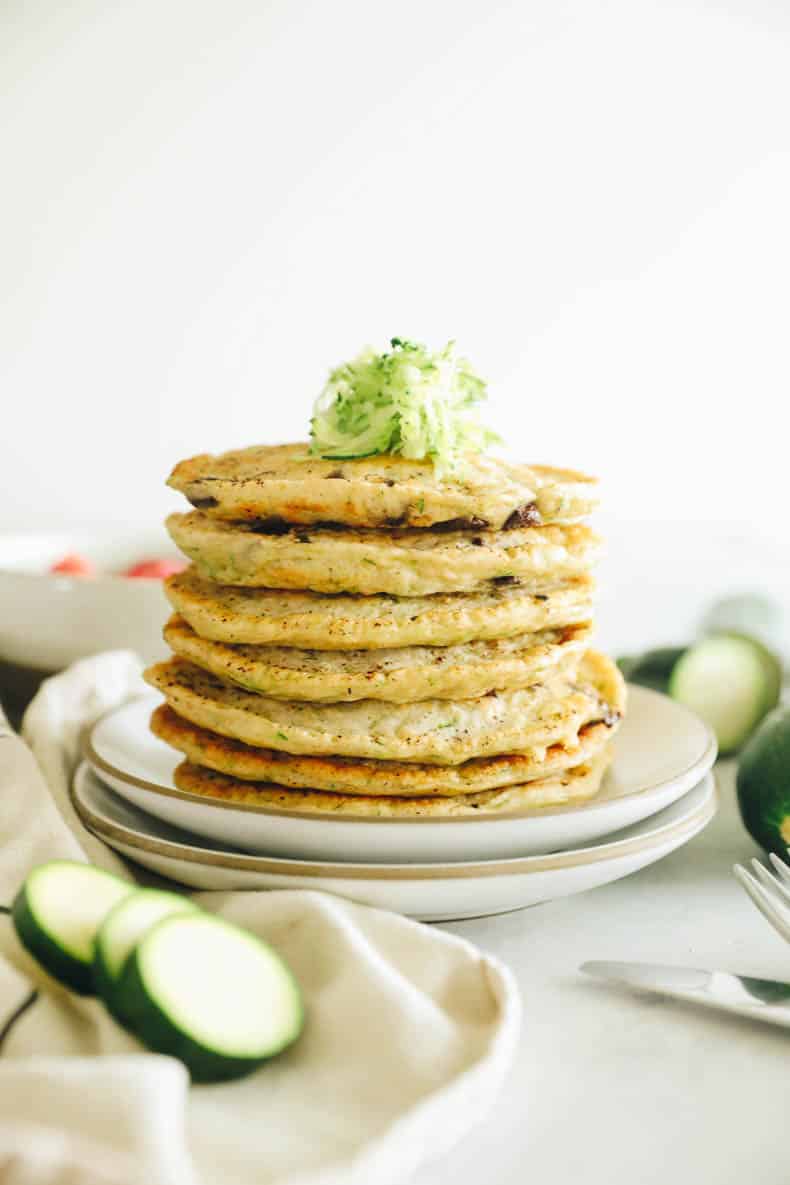 zucchini pancakes stacked on a plate.