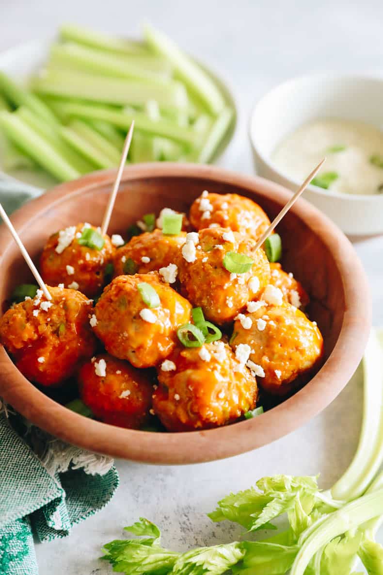 buffalo chicken meatballs in brown bowl with toothpicks.