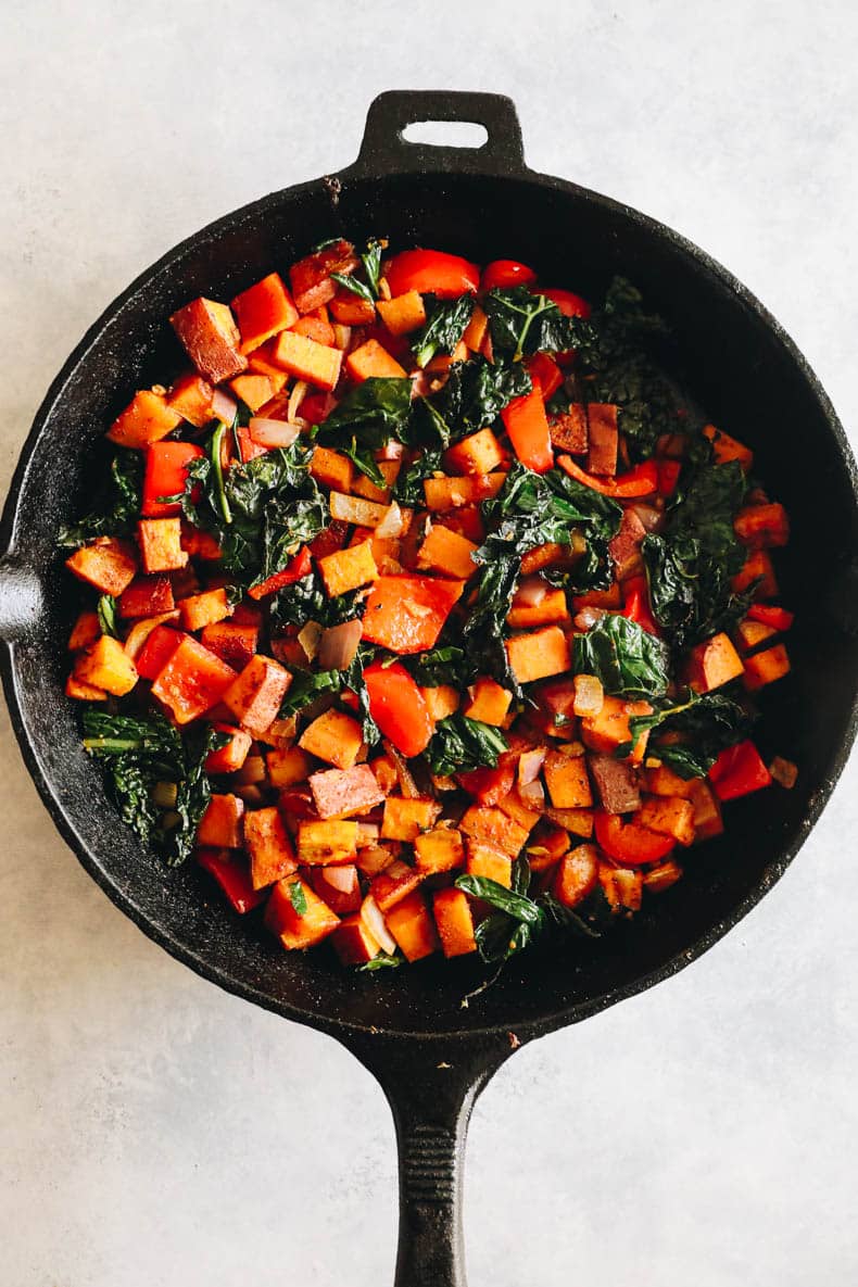 sweet potatoes, bell pepper and kale roasted in a cast iron skillet.