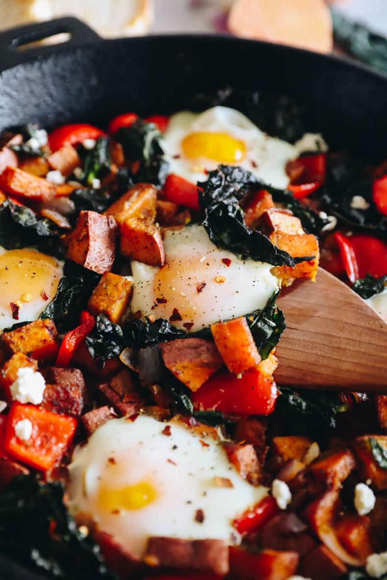 close-up of baked eggs with sweet potatoes and kale