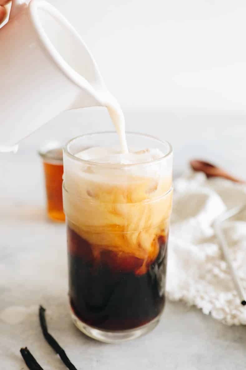vanilla sweet foam being poured into a cup of cold brew