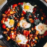 overhead of roasted sweet potatoes with bell peppers, kale and baked eggs.