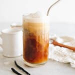 vanilla sweet cream cold brew in a clear glass with vanilla cold foam and a metal straw.