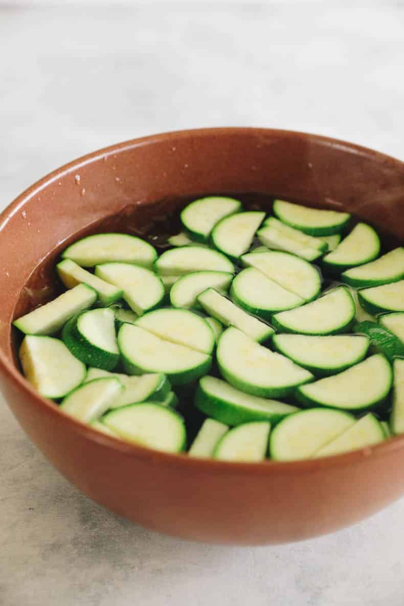 Blanched zucchini in an ice bath.