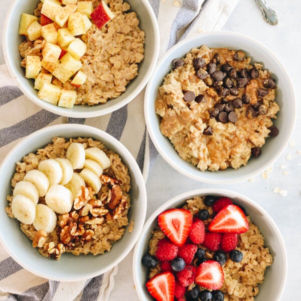 4 bowls of oatmeal each topped with different toppings.