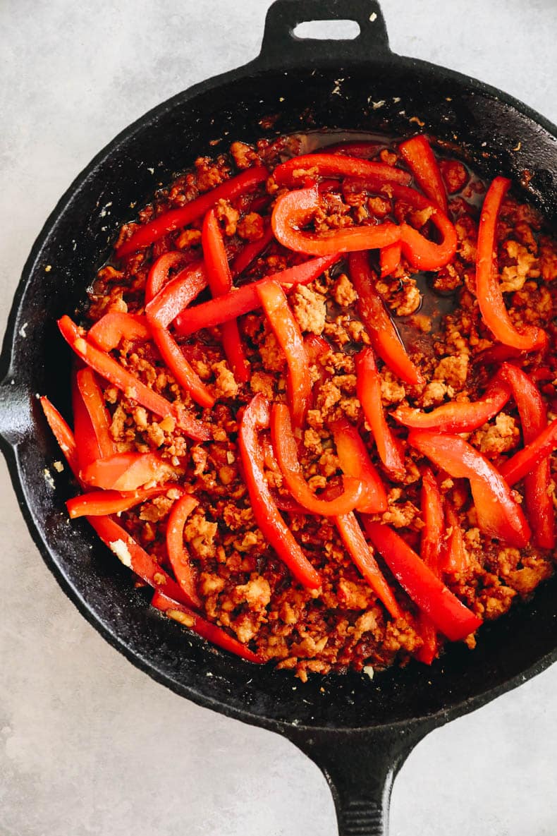 ground gochujang chicken in a cast iron with bell peppers