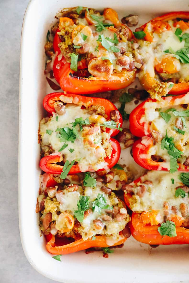 Quinoa stuffed bell peppers topped with melted cheese and baked.