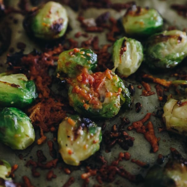 upclose image of a smashed brussel sprouts sprinkled with crispy parmesan bits.