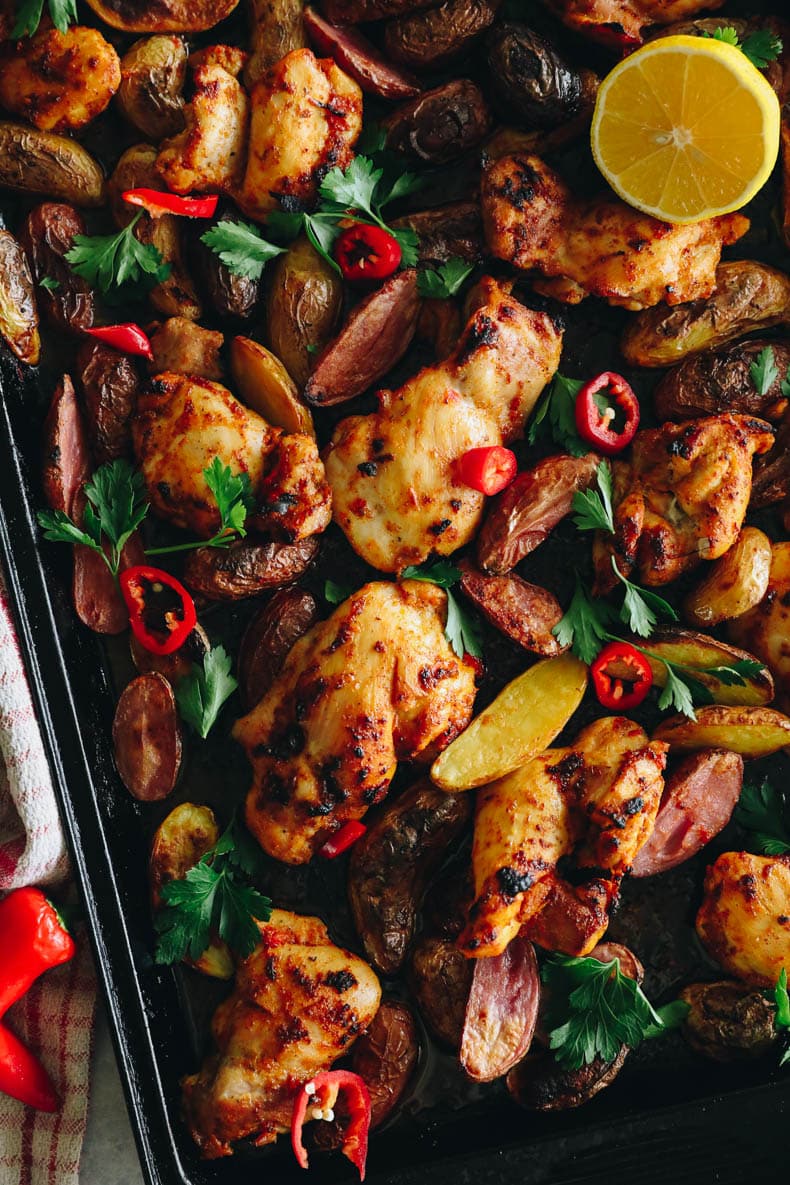 overhead image of peri peri chicken thighs with roasted potatoes