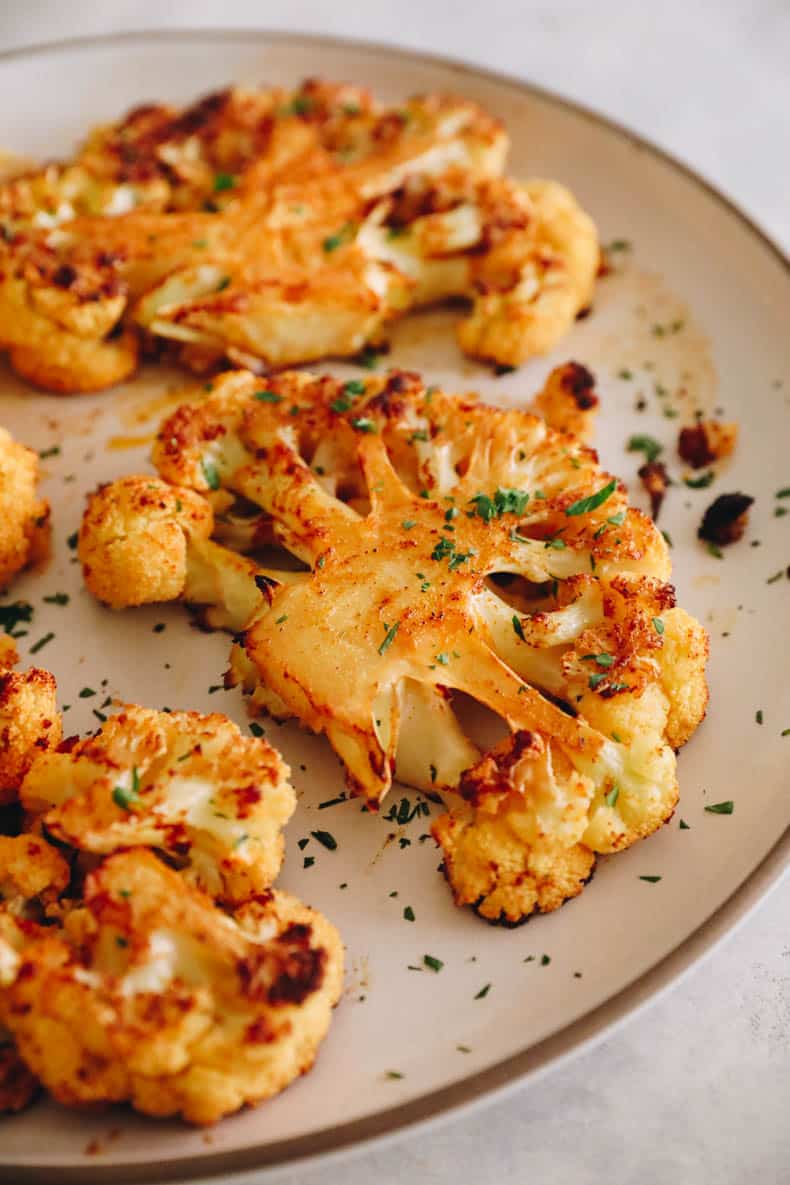 cauliflower steak on a white plate.