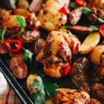 peri peri chicken thighs on a sheet pan with roasted potatoes, fresh parsley and bird's eye chilis