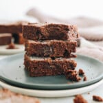 3 protein brownies stacked on top of each other on a plate plate.