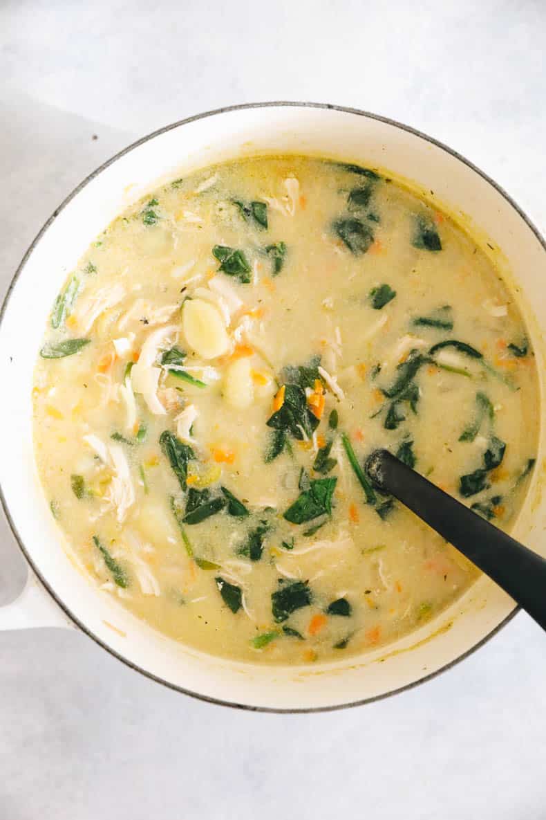 chicken gnocchi soup with spinach and potato gnocchi in a large white pot.