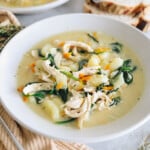 chicken gnocchi soup with spinach, potato gnocchi and shredded chicken in a large shallow bowl.