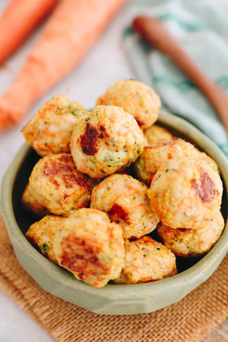 close up of a green bowl with baked chicken meatballs.