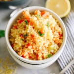 thick easy and delicious pastina soup in a white bowl topped with lemon and parmesan.