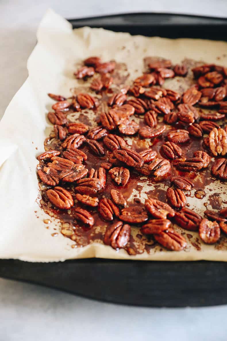 Sweet and spicy toasted pecans on a baking sheet.