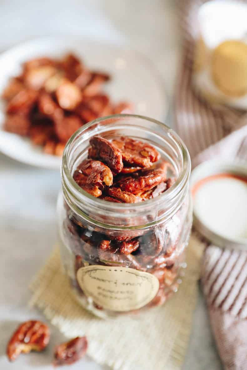 Sweet and spicy roasted pecans in a glass jar.