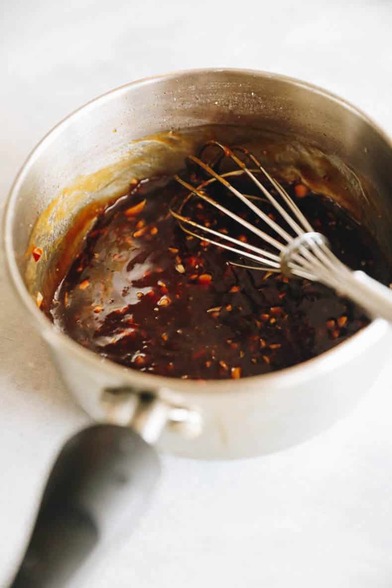 honey garlic sauce in a small sauce pan with a whisk