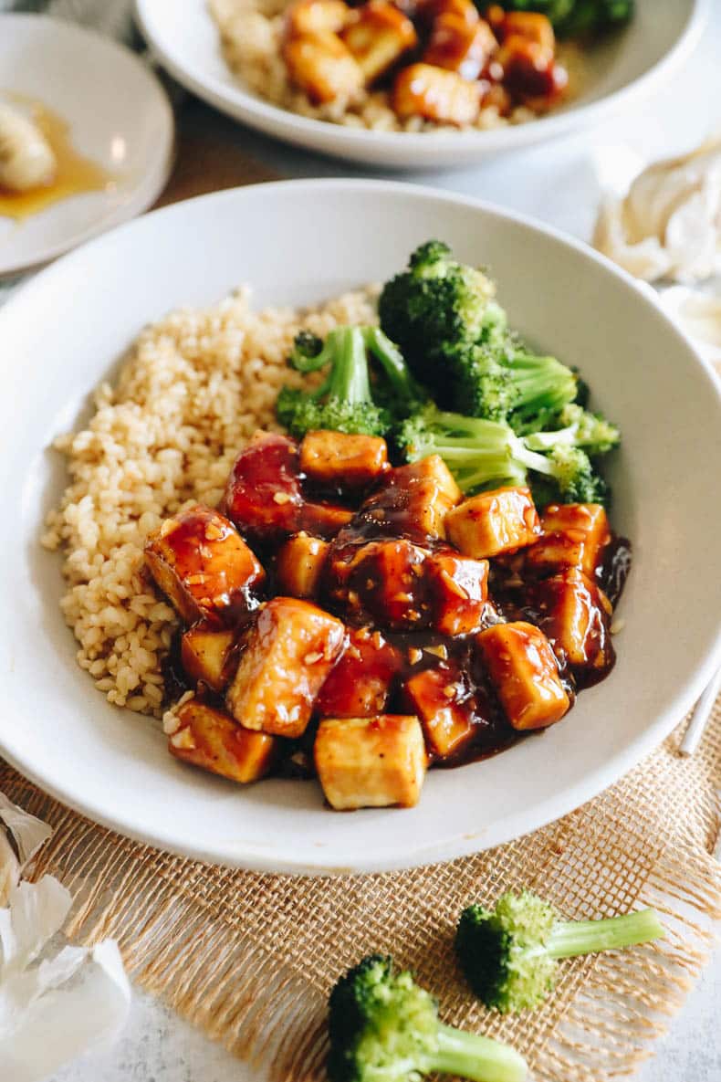 honey garlic baked tofu in a white bowl with rice and broccoli