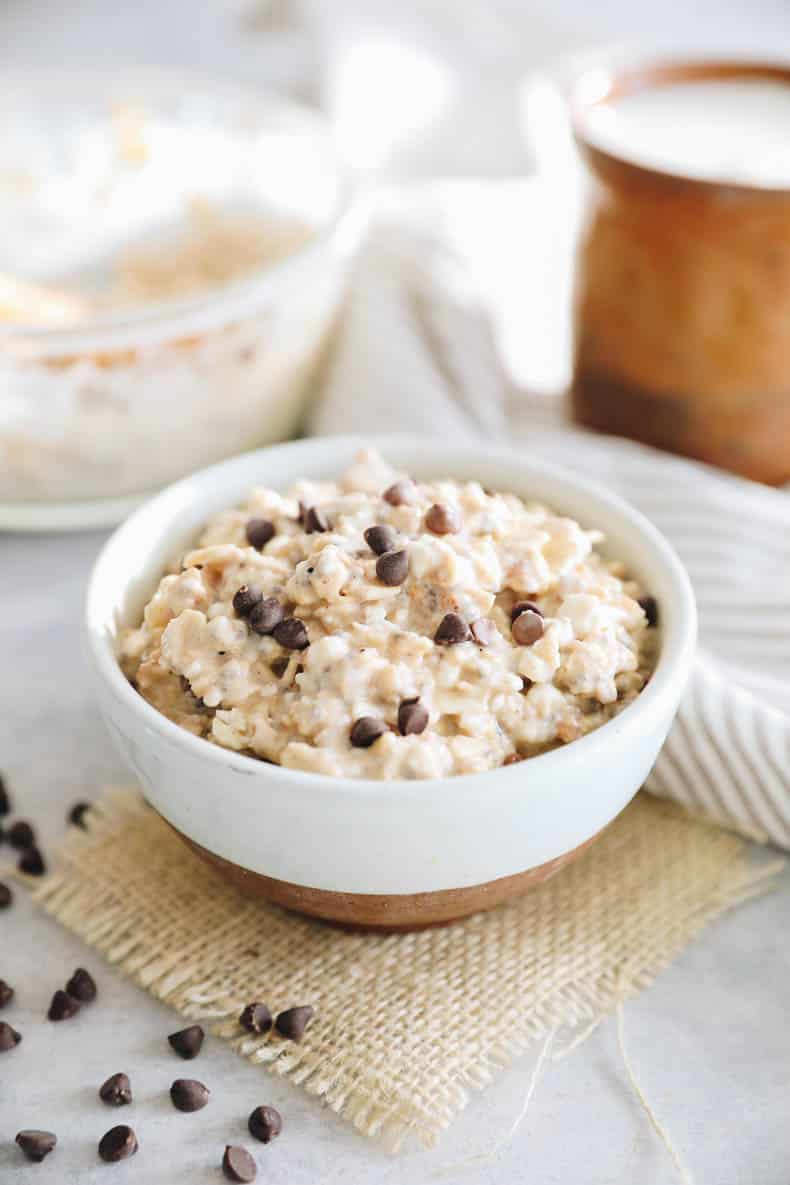 Cheesy Cookie Dough Overnight Oats in brown and white bowls with chocolate chips.