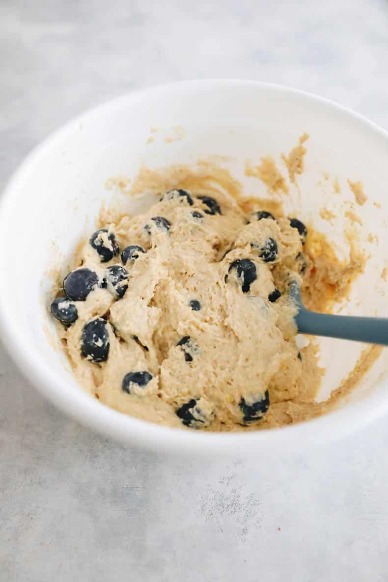 Lemon blueberry muffin batter in a white mixing bowl.