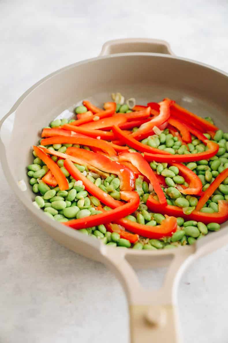 Add bell peppers and edamame to pot.