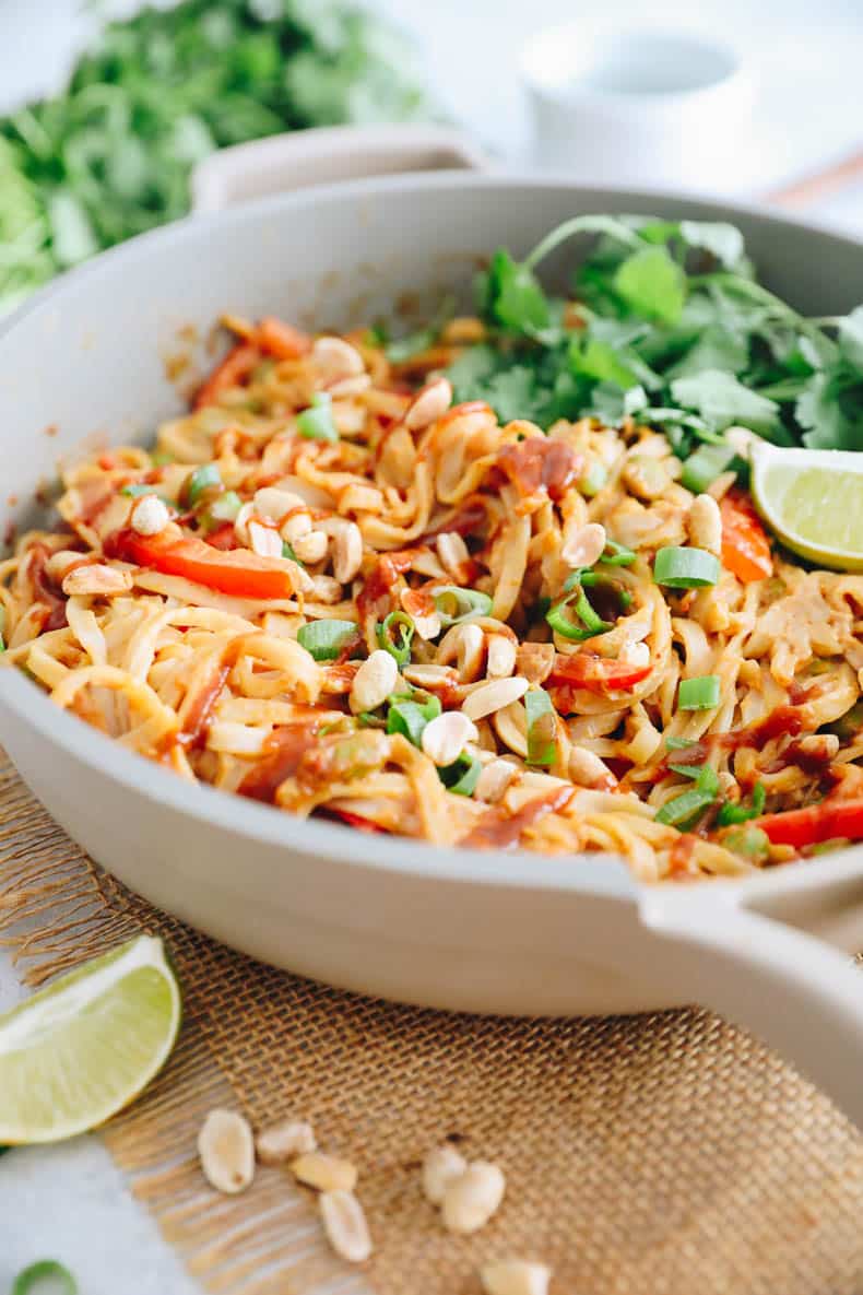 Add the peanut noodles to the pot and add the scallions, Sriracha, lime wedges and crushed peanuts