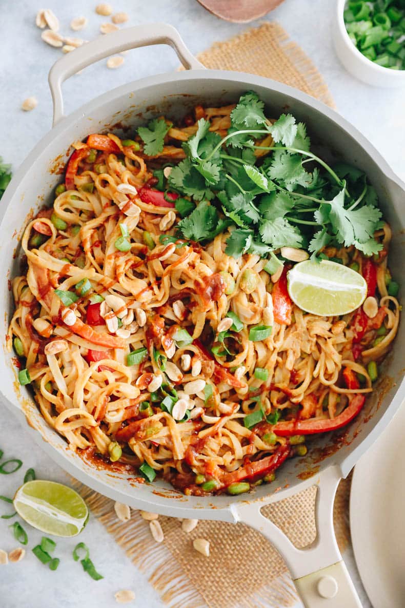 Top view of rice noodles with spicy peanut sauce of bell pepper and edamame