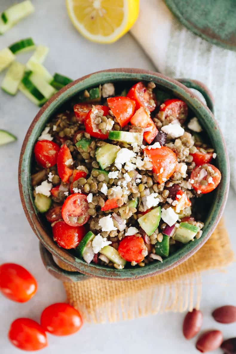 Overhead image of Greek lentil salad in a big green bowl.